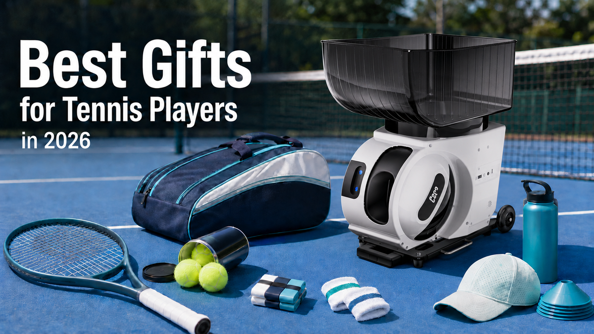 Tennis ball machine, ball picker, towel, balls, and wrapped gift beside a court